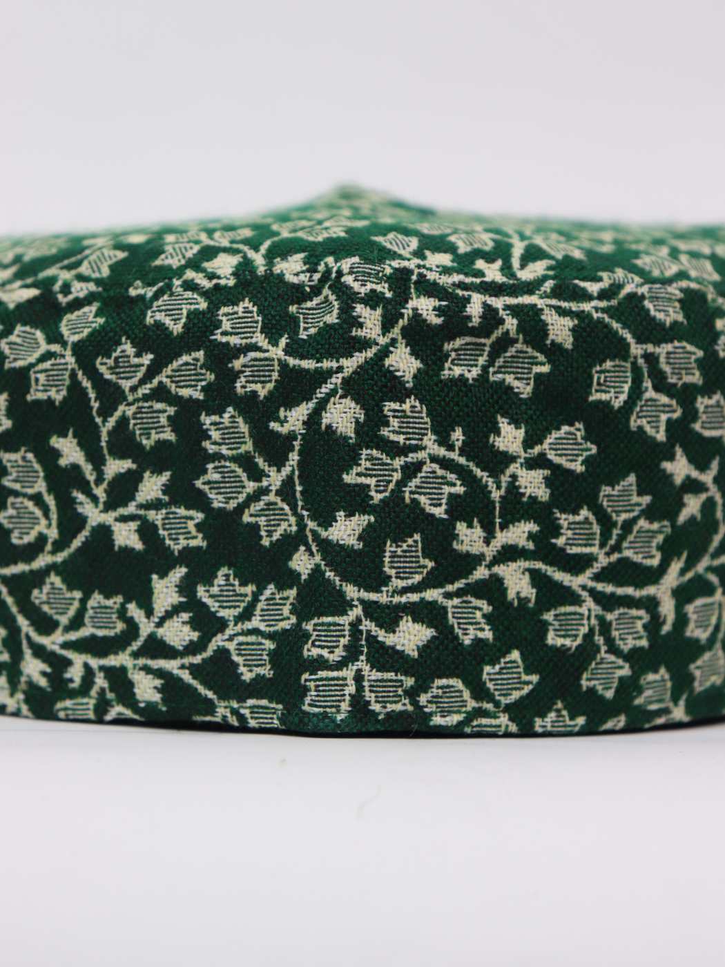 green cap from Kashmir in kani woven pattern