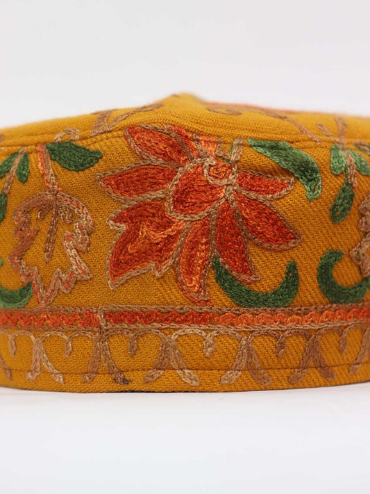 aari embroidery against cap in mustard colour wool