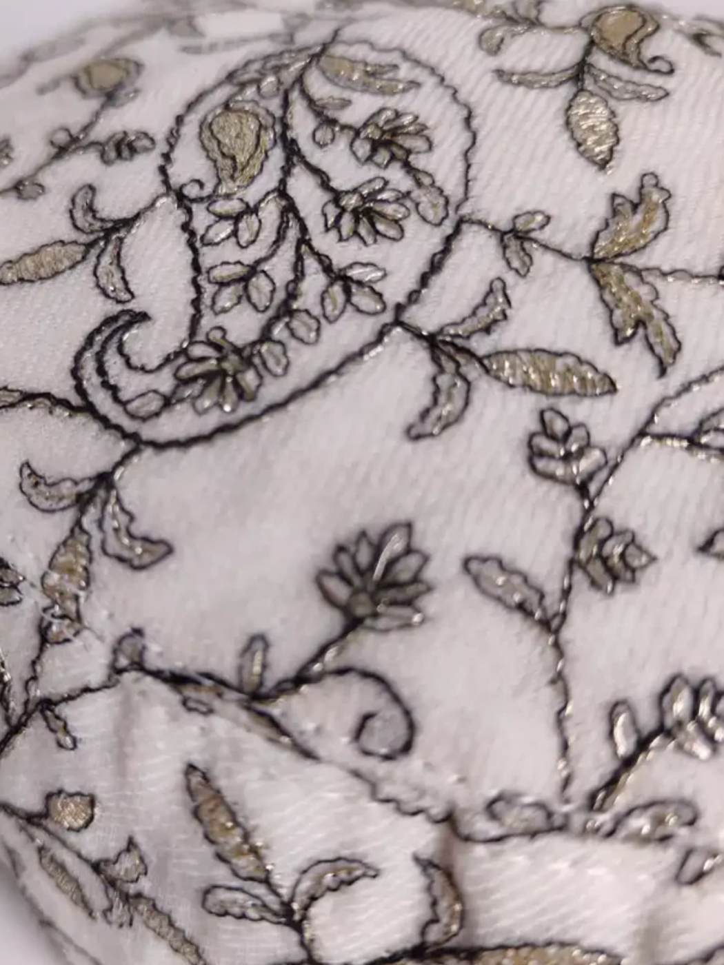 paisley motif in zari work on the white cap