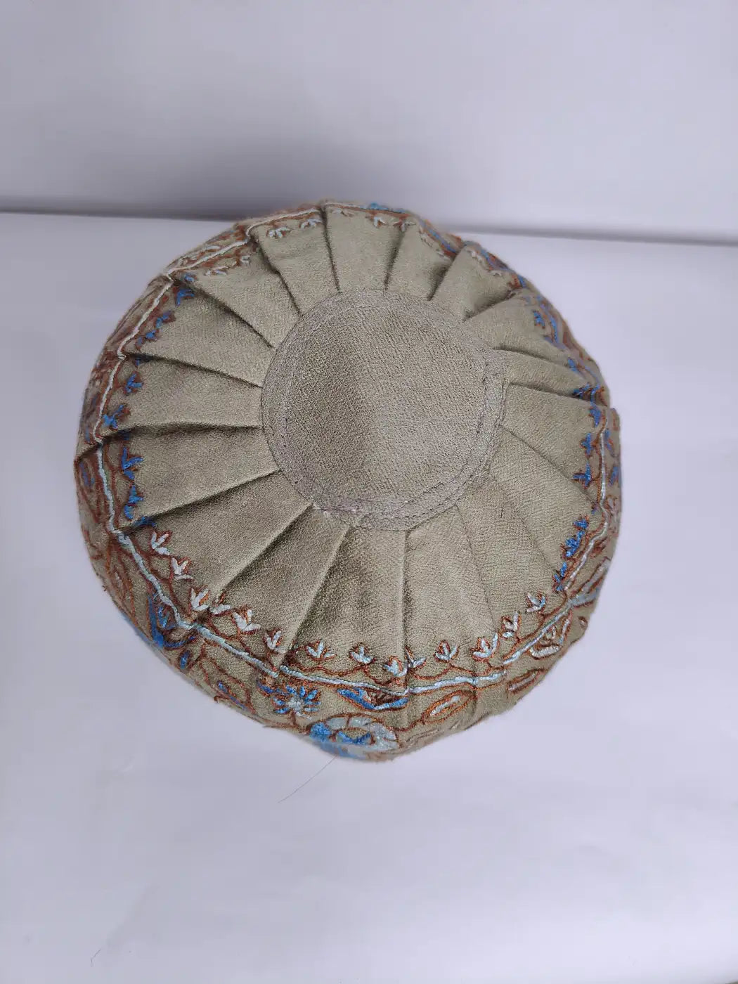 top side of the beige hue kashmiri mens cap neatly folded