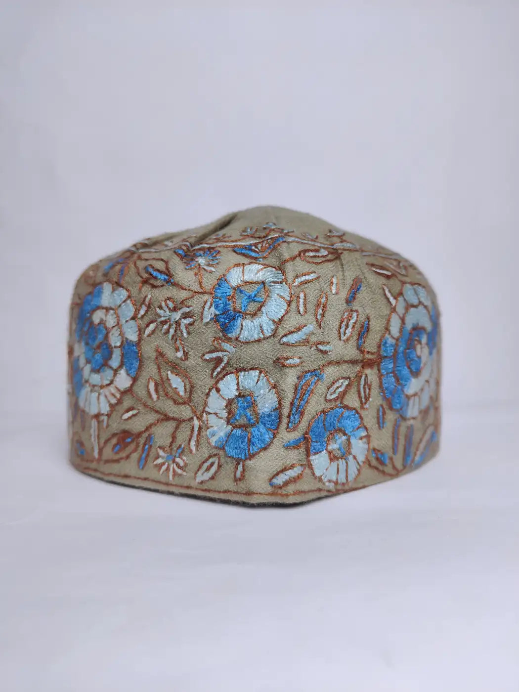 multi color floral patterns in hand sozni and paper machie work across sides of the kashmiri topi
