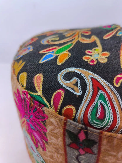 kalamkari embroidery against black base of the topi