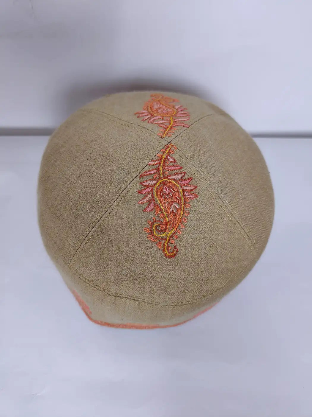 top side of the beige Kashmiri round cap in hand sozni paisley design 