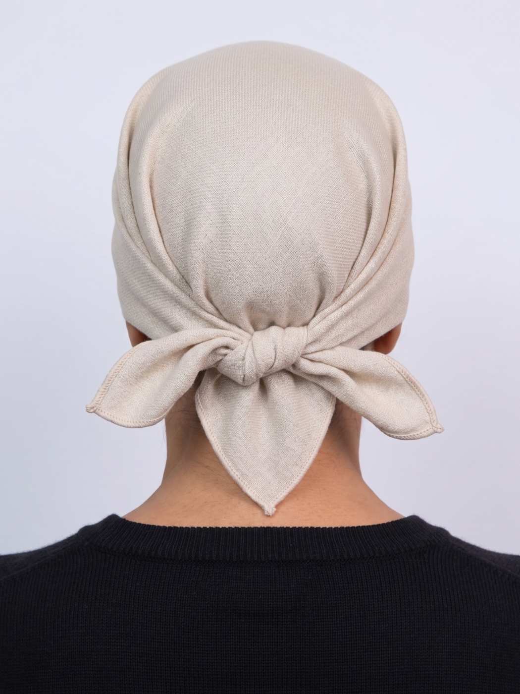 Person wearing a beige bandana headscarf made from pure pashmina