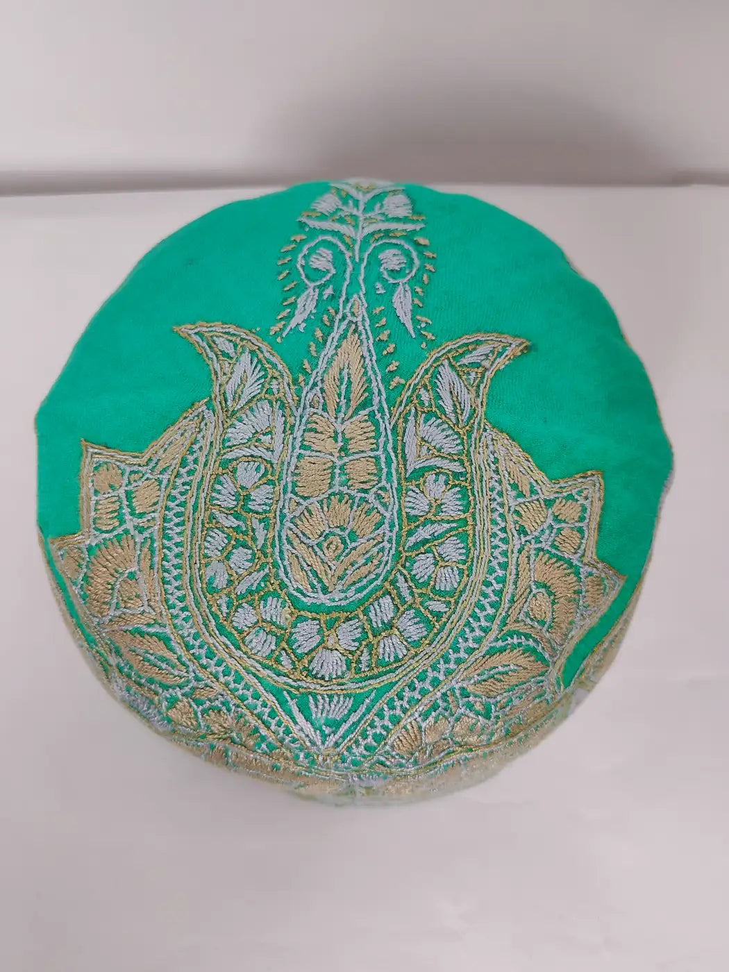 green cap with paisley motif on top side in sozni embroidery 