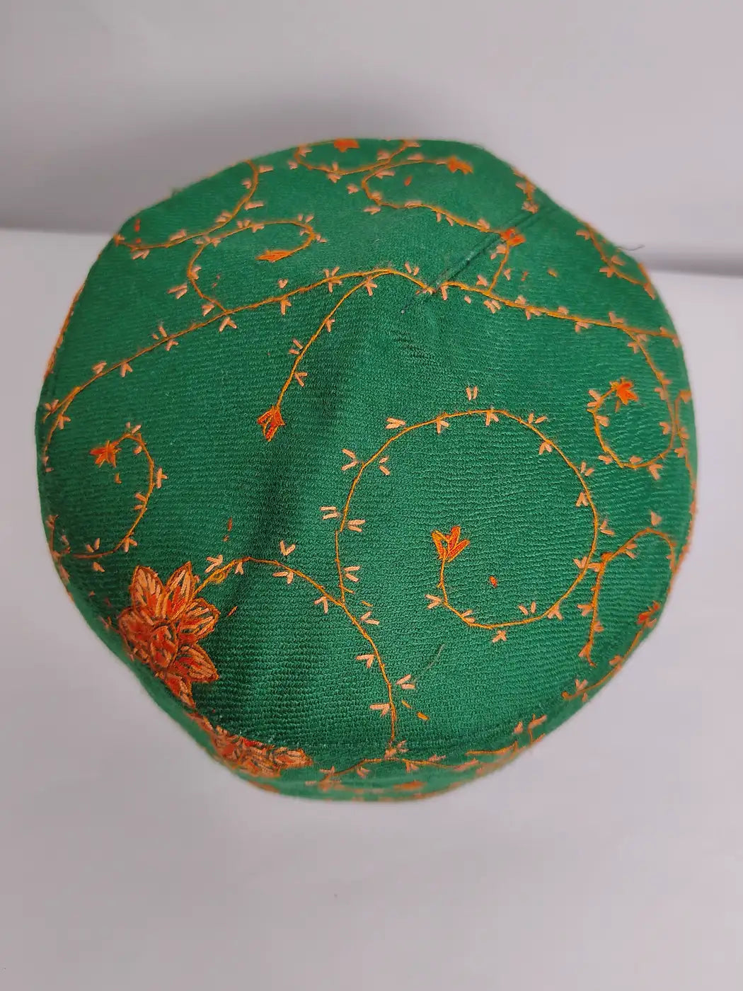Green skull cap with orange floral embroidery
