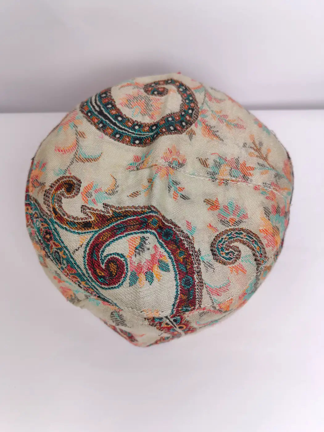 beige Kashmiri cap with floral kani pattern on top side 