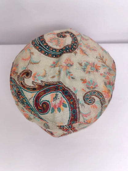 beige Kashmiri cap with floral kani pattern on top side 