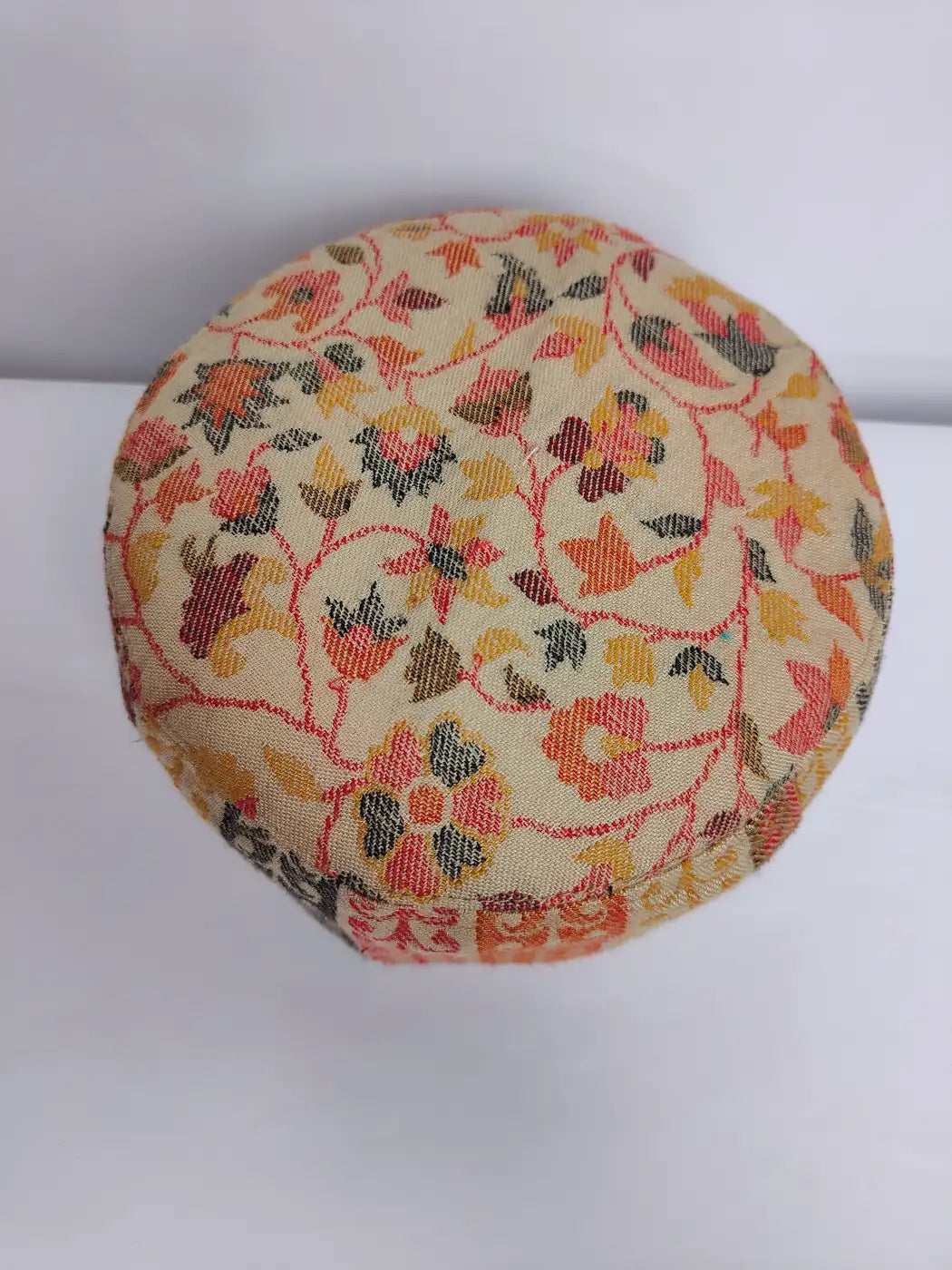 beige kani cap with floral patterns on top side 