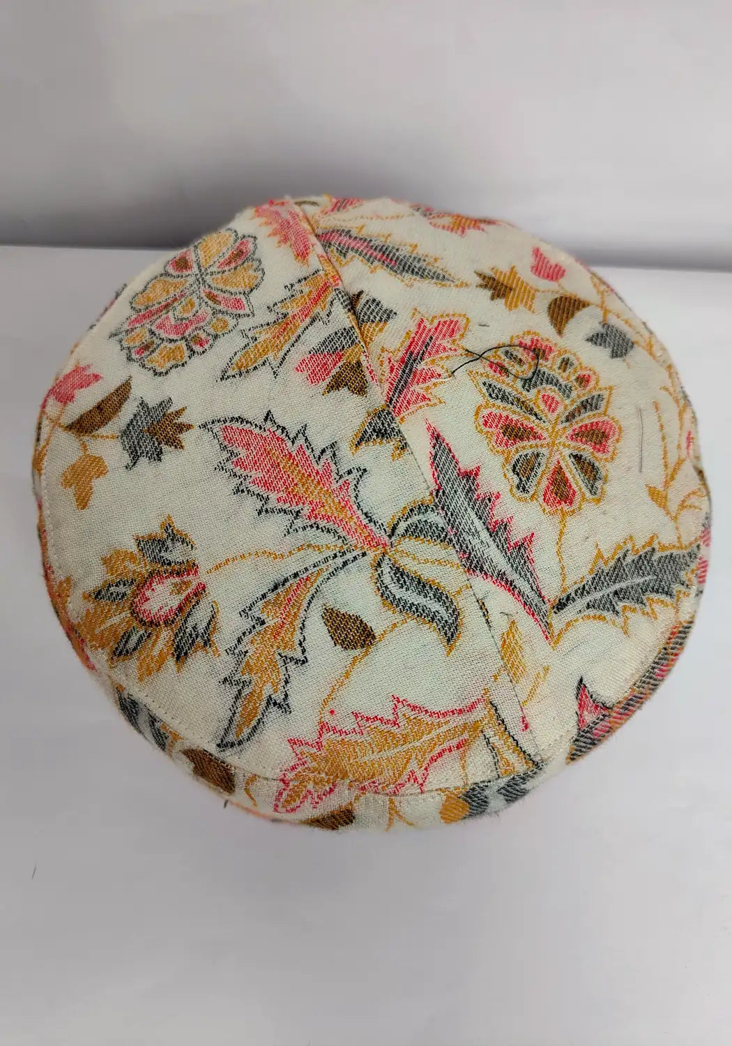 top side of round kani cap with floral kani work
