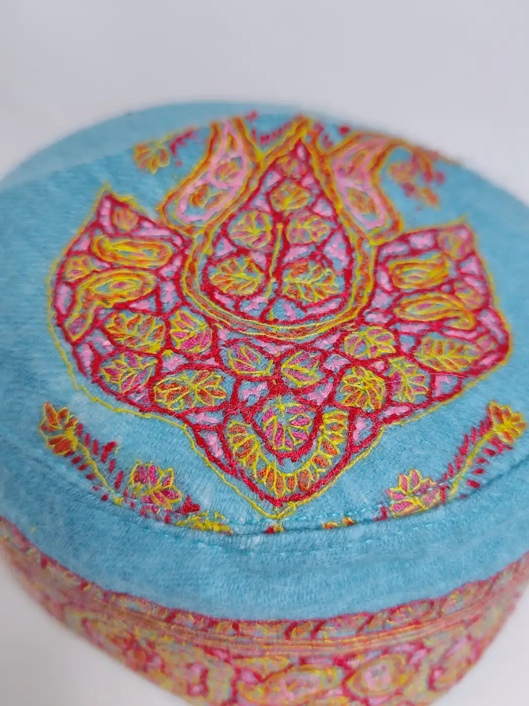 Hand Sozni embroidery against blue fabric