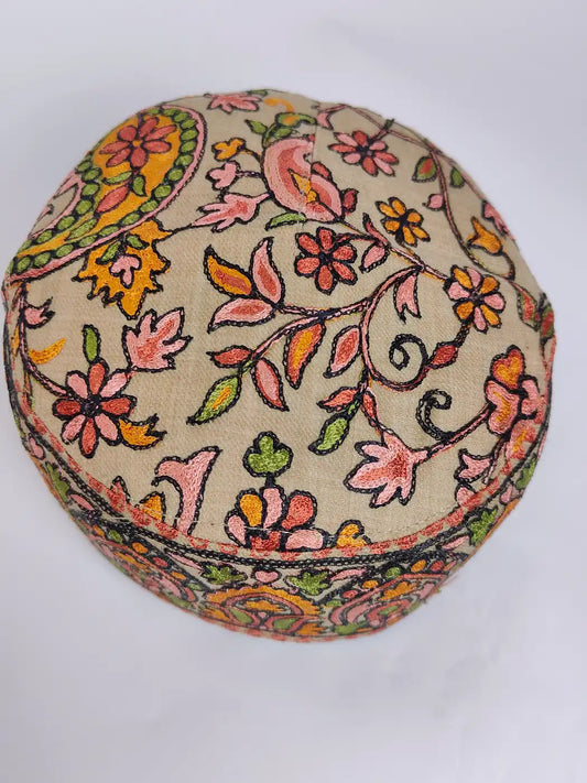 beige cap with nalki aari work on top side 