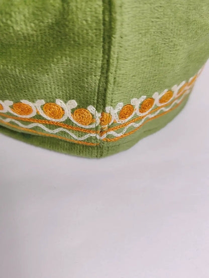 green cap in velvet with aari embroidery across sides