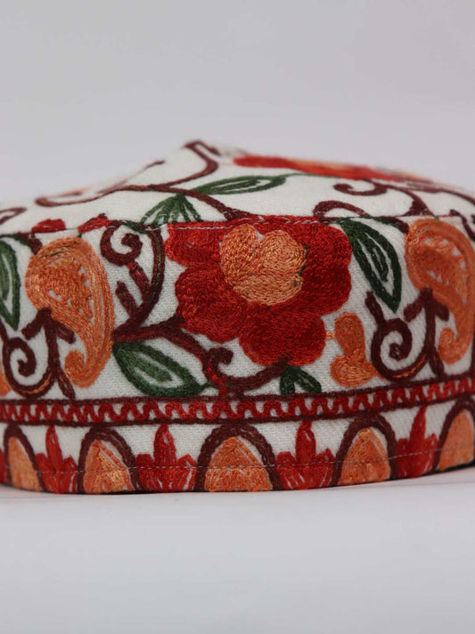 white cap with aari embroidery on top side