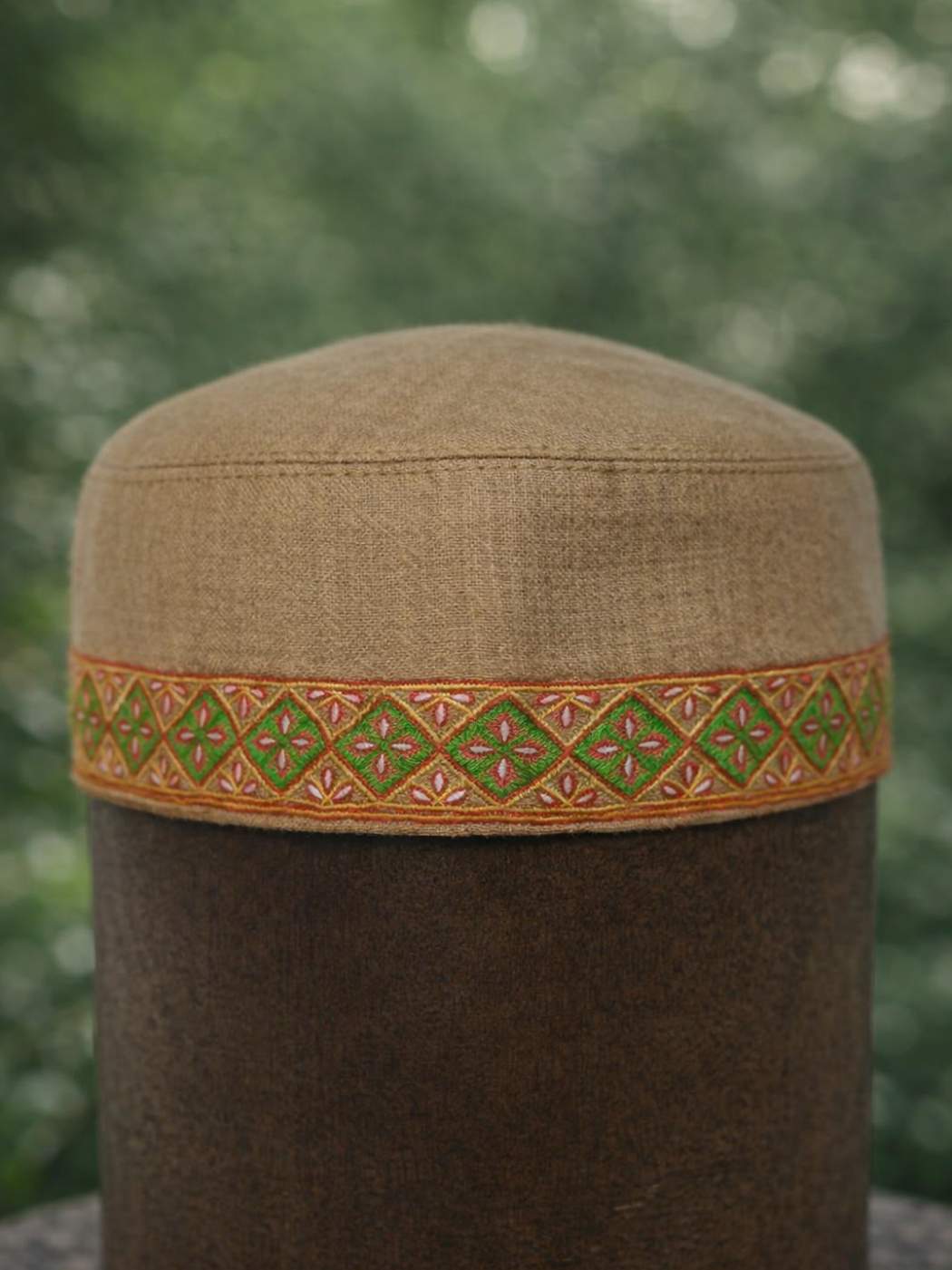 geometrical pattern in sozni work across sides of this beige Kashmiri topi 