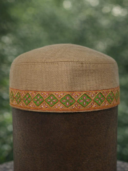 geometrical pattern in sozni work across sides of this beige Kashmiri topi 
