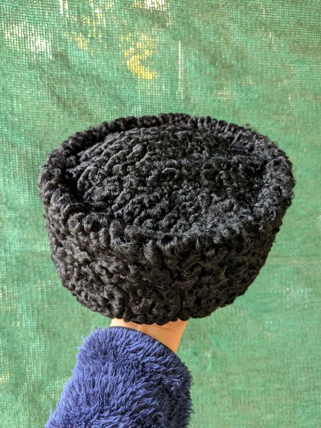black karakul cap in turkish cap in hand of a person